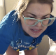 A pudgy, nerdy girl wearing glasses takes a shit while sitting on a toilet and wipes her ass. Audio is compressed, but there are a couple somewhat audible plops. Presented in 720P HD. Over 4 minutes.